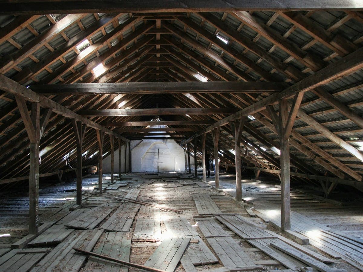 Leerer Dachboden mit Holzbalken und Dielenboden